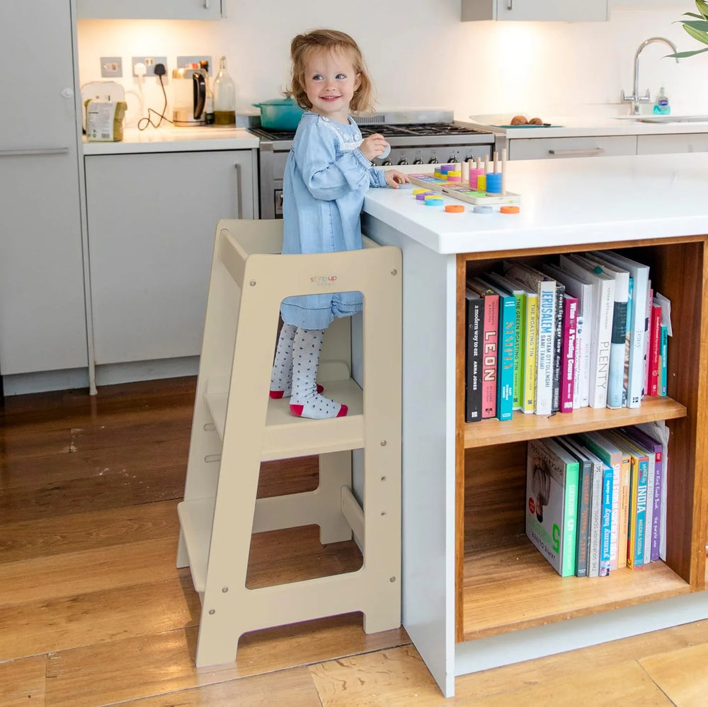 image showing a child in toddler tower playing with wooden toy